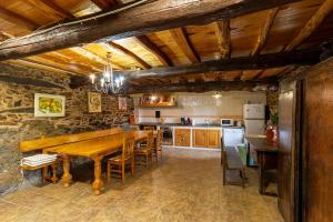 a large kitchen with a wooden table and chairs at Casa Ruperto in Doade