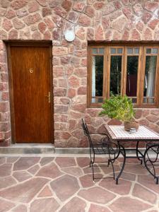 eine Terrasse mit einem Tisch und Stühlen vor einem Steingebäude in der Unterkunft Boutique Guesthouse Dar Zohra in Marrakesch