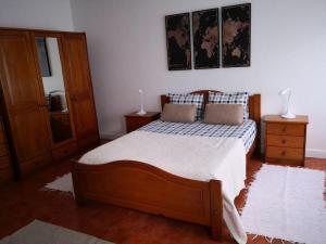 a bedroom with a wooden bed with two pillows on it at Beach and Surf Lovers in Costa da Caparica