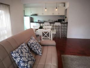 a living room with a couch and a kitchen at Beach and Surf Lovers in Costa da Caparica