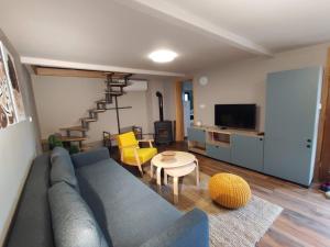 ein Wohnzimmer mit einem blauen Sofa und einem Tisch in der Unterkunft Bakino brdo - Granny's hill in Bakovčica