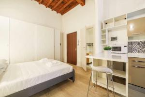 una camera bianca con letto e cucina di UNYCA - Heart of Florence House a Firenze