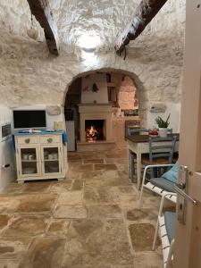 kuchnia z kamienną podłogą i kominkiem w obiekcie trulli mancinella w mieście Locorotondo