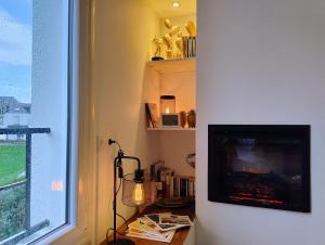 uma sala de estar com uma televisão e uma janela em Ti Kabanouz em Arzon