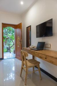 a desk with a laptop and a chair in a room at Sanur Lodge in Sanur