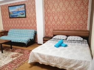 um pequeno quarto com uma cama e uma mesa em Северное Сияние 41 этаж 01 em Astana