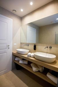 a bathroom with two sinks and a mirror at Parco dei Principi - Resort & Spa in Torre San Giovanni Ugento