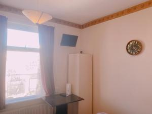 a room with a refrigerator and a clock on the wall at Kings Court Hotel in Blackpool
