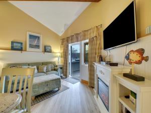 un soggiorno con un divano e una TV di 202 Pointes North Inn a Charlevoix