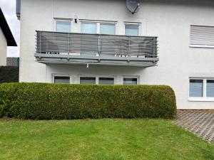 a building with a balcony on top of a bush at F&M Wohnungen in Olpe in Wenden