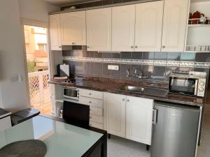 a kitchen with white cabinets and a counter top at APT Borras & Roca Plana, fronte mare in Es Pujols +19 photos