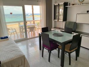 a dining room with a table and chairs and the ocean at APT Borras & Roca Plana, fronte mare in Es Pujols
