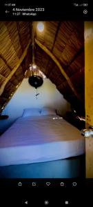 Cama en habitación con techo de madera en Ecohotel Akuaipa, en San Juan del Cesar