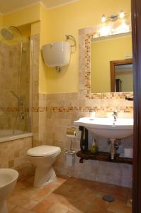W łazience znajduje się umywalka, toaleta i lustro. w obiekcie Casale Favilluta w mieście Petrignano