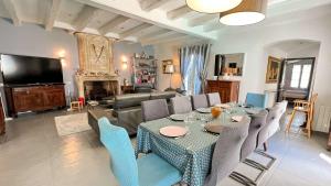 a living room with a table and chairs and a television at Superbe villa d'architecte avec piscine chauffée in Loix