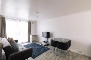 Una sala de estar con un sofá y un escritorio. en Amazing 1 Bed Flat with Free Parking, en Croydon