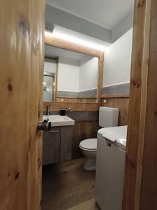 ein Badezimmer mit einem WC, einem Waschbecken und einem Spiegel in der Unterkunft Casa Andrea in Pila