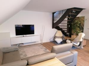 a living room with a couch and a tv at Gemütliche Wohnung auf 2 Etagen in Lengerich