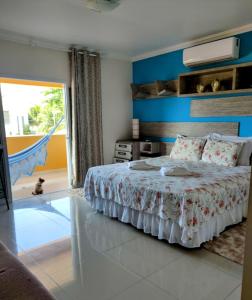 a bedroom with a bed with a blue wall at Pousada Marcos in Guarujá