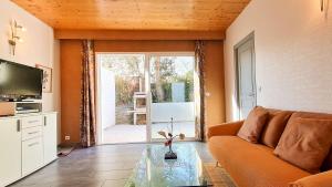 een woonkamer met een bank en een glazen tafel bij Charmante villa à proximité de la plage du Petit Sergent in Le Bois-Plage-en-Ré