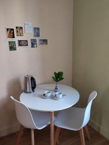 una mesa blanca con dos sillas y un jarrón en ella en Entre Meuse et forêt, en Revin