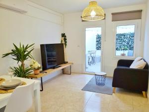 een woonkamer met een tv en een bank en een tafel bij Apartamento céntrico con patio privado in Tarragona