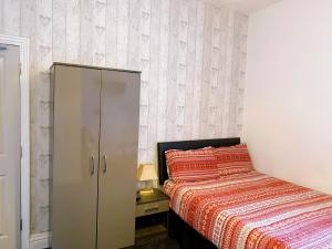 a bedroom with a bed and a cabinet next to it at Kings Court Hotel in Blackpool