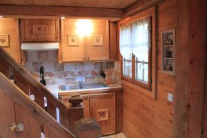 a kitchen with wooden cabinets and a sink in a cabin at Les Greniers du Mont Blanc in Passy