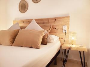 een slaapkamer met een bed met een houten hoofdeinde en een lamp bij Apartamento céntrico con patio privado in Tarragona