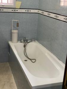 bañera con manguera pegada a la pared en 3 Bedroom Spacious Apartment en Okunola