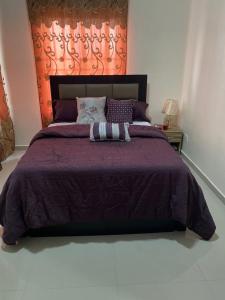 a bedroom with a large bed with a purple comforter at 3 Bedroom Spacious Apartment in Okunola
