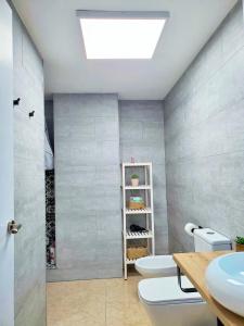een badkamer met 2 toiletten en een wastafel bij Apartamento céntrico con patio privado in Tarragona