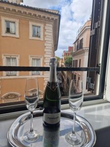 een fles wijn op een tafel met twee glazen bij Corso Suite Style in Rome