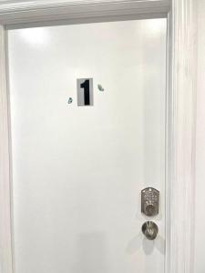 een witte deur met een zwarte nummer één erop bij TononHouse in Toronto