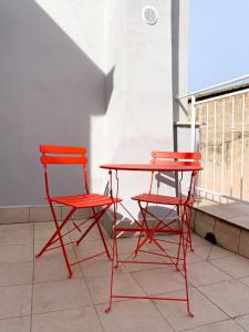 2 sillas rojas y una mesa en el balcón en Le Vie del Borgo, en Sannicandro di Bari