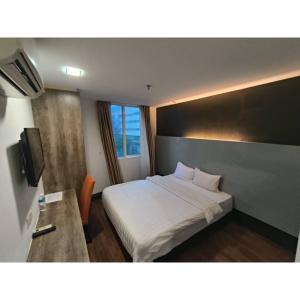 ein Hotelzimmer mit einem Bett und einem TV in der Unterkunft Sakura Elite Kuala Lumpur in Kuala Lumpur