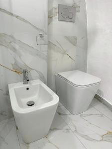 La salle de bains blanche est pourvue de toilettes et d'un lavabo. dans l'établissement Dimora Bianca, à Catane