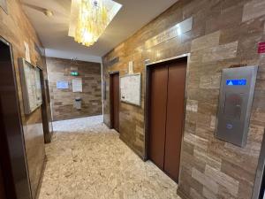 a hallway with two elevators in a building at Private room in a shared apartment - Metro 7 and Tramway T3a in Paris