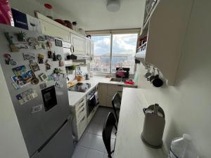 cocina con nevera y encimera en Private room in a shared apartment - Metro 7 and Tramway T3a, en París