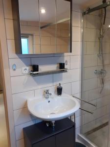 een badkamer met een wastafel en een spiegel bij Ferienwohnung Tina in Wunstorf