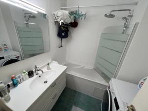 a bathroom with a sink and a shower and a tub at Guest room in a shared apartment - Metro 7 and Tramway T3a in Paris +11 photos