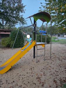 a child on a slide at a playground at MH-MAUFAY -- Mobil'home au Coeur de la Vendée in La Boissière-de-Montaigu