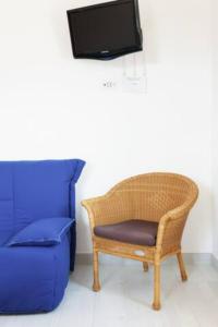 アシェーアにあるCasa Vacanze Nonna Rosaria al centro di Ascea Marinaの籐の椅子、テレビが備わります。