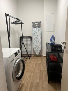 a laundry room with a washing machine and a shelf at Charming Homes - Studio 16 in Wolfsburg