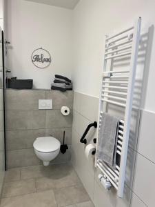 a bathroom with a toilet and towels in it at Charming Homes - Studio 16 in Wolfsburg