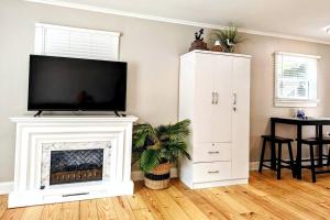 a living room with a fireplace with a flat screen tv at Cute & Cozy 2/1 Lakeview House on Chain O Lakes in Fox Lake