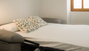 eine Couch mit zwei Kissen darüber in der Unterkunft Catalina Suites Apartments Downtown Valencia in Valencia