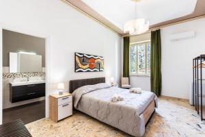 a bedroom with a large bed and a sink at Le Torrette Rooms and Apartments in Avola