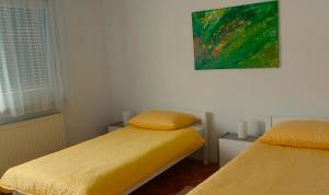 een slaapkamer met 2 bedden en een schilderij aan de muur bij EXCELLENT - Kuća za odmor u Županji in Županja