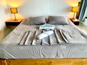 a bed with two towels and pillows on it at Nido Aracari in San Pedrillo